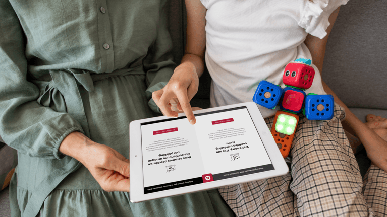 An adult teaches a young girl how to use the CIRA Canadian Shield app on a tablet.