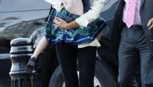 Suri Cruise plays shy in mom Katie Holmes' arms