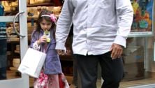 Suri Cruise drinks juice with her bodyguard
