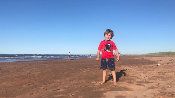 Hadrien Trudeau smiling at the camera at the beach