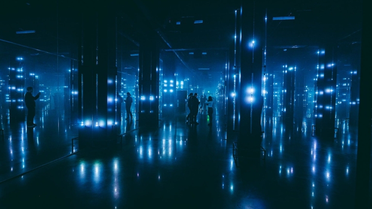 A dark room with little blue lights illuminating the room - part of AREA15 in Las Vegas