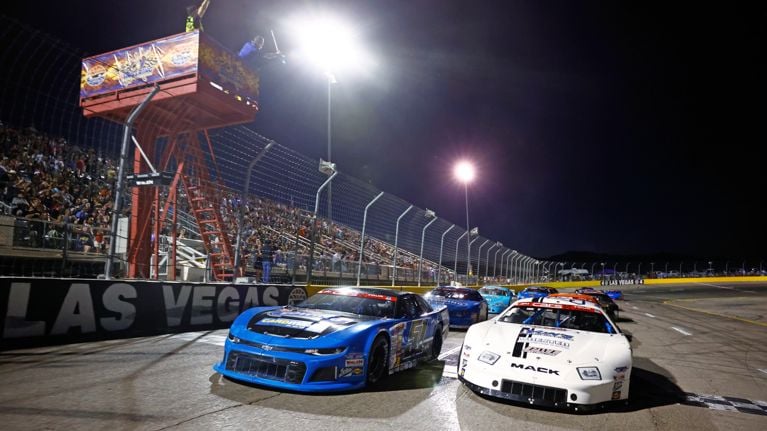 Two cars driving down the Las Vegas Motor Speedway 
