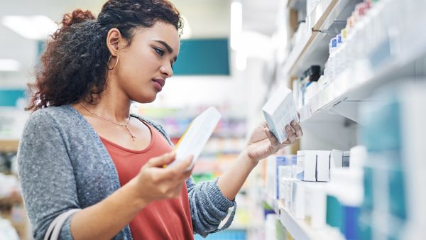 Shot of a young woman browsing the shelves of a pharmacy
