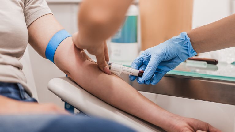 Close-up Of Doctor Taking Blood Sample From Patient's Arm in Hospital for Medical Testing