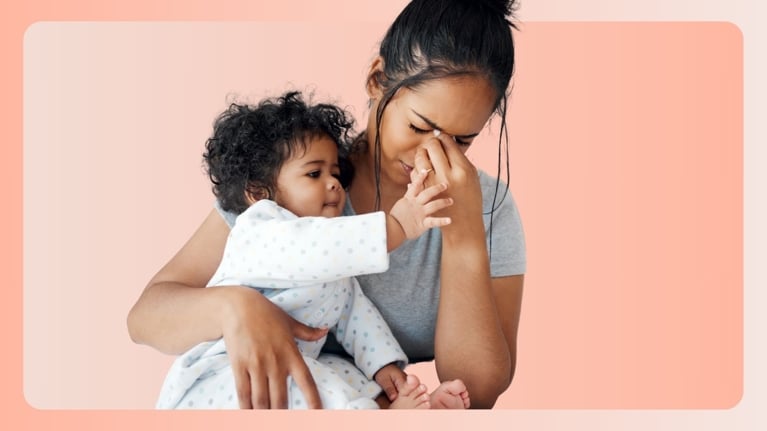 A mother holds her baby while rubbing her forehead in visible stress, as the baby gently touches her face. The moment captures the emotional tension of parenting while managing exhaustion and the demands of caregiving.