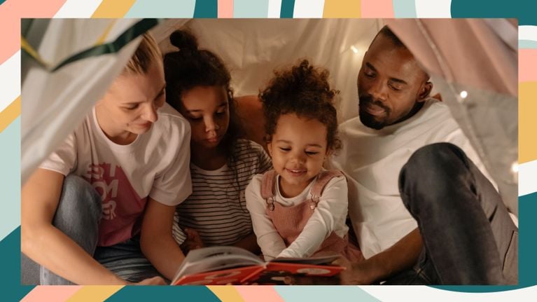 diverse family of four sits closely together inside a cozy blanket fort, reading a picture book. The group includes two adults and two young children. Warm lighting and soft surroundings create an intimate and joyful atmosphere. A colorful border with abstract shapes frames the image.