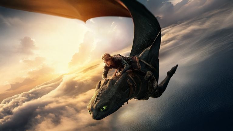 A CGI-enhanced image of a young man riding on a dragon's back in the sky