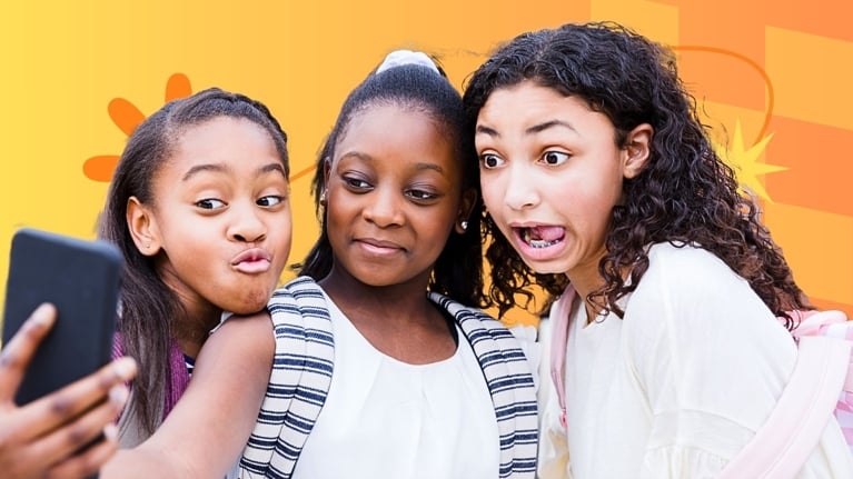Three tween girls take a selfie together, smiling and making expressive faces. They wear backpacks and stand against a colorful orange and yellow background with playful graphic elements.