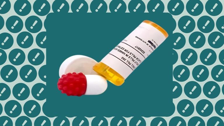 A prescription pill bottle lies open with a red, bumpy magnetic fidget toy shaped like a capsule spilling out. The background features a pattern of white exclamation marks inside teal circles, emphasizing caution or warning.