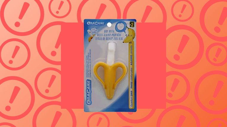 The Oracare Baby Brush toothbrush in yellow banana shape is shown in its original packaging against a warning icon background; Health Canada has recalled this Dollarama-sold infant product due to a risk of breaking and choking.