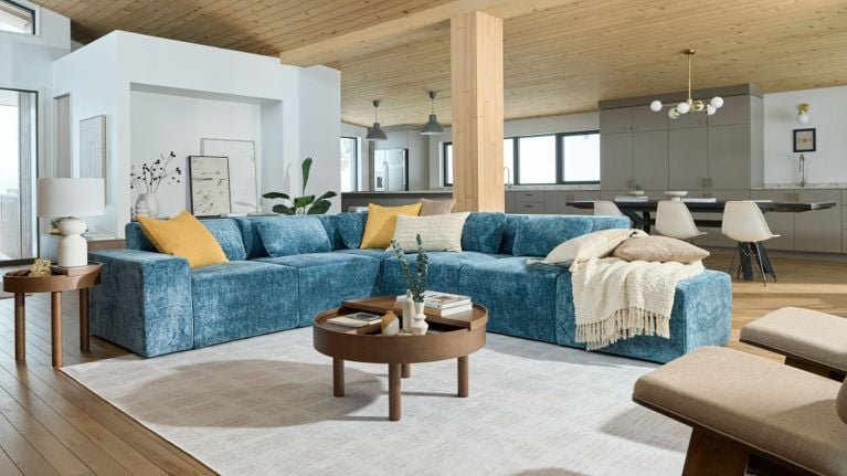 Partially assembled Cozey Atmosphere modular couch with exposed storage compartments and cushion covers laid out on the floor.