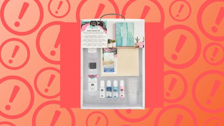 American Crafts Resin Starter Kit displayed in its packaging, featuring bottles of resin, colorants, and crafting tools, set against a red-orange background with warning icons. The kit has been recalled in Canada for lacking proper chemical hazard labels.