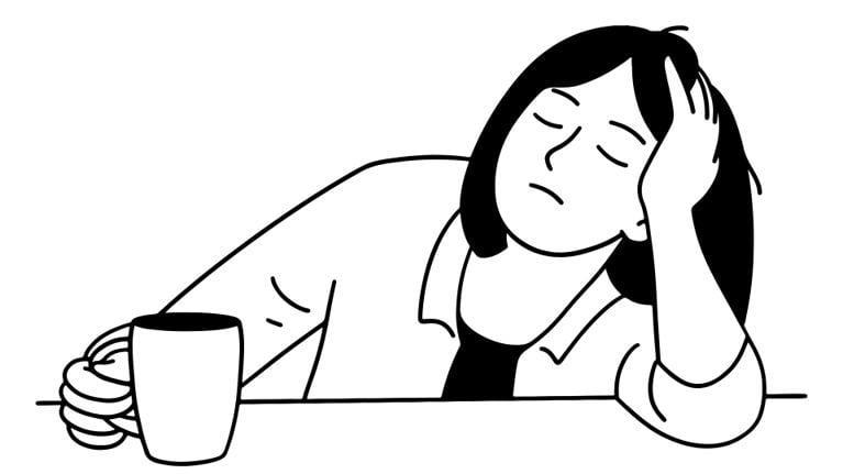 A tired woman rests her head on one hand with eyes closed, while holding a coffee mug in the other hand, looking exhausted.