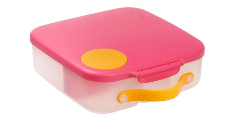 A square bento-style lunchbox with a bright pink lid, yellow latch, and yellow circle on top.