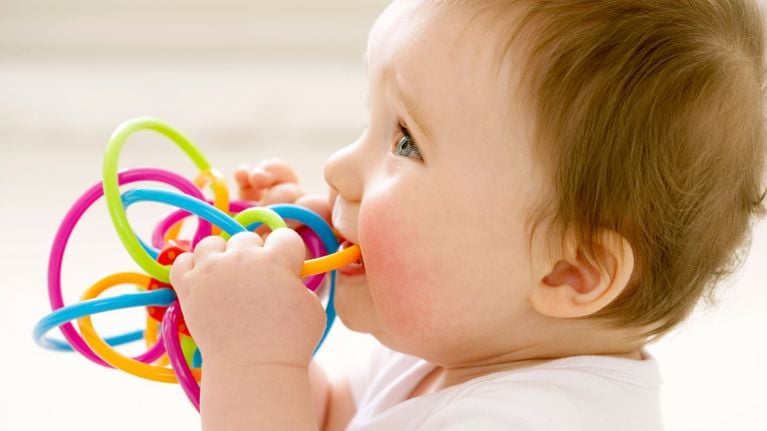 A baby chewing on a teething ring