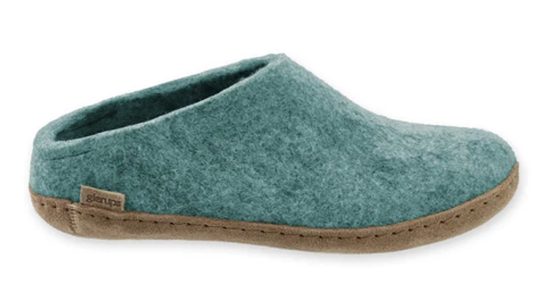 A pair of teal felt slip-on slippers with a low-profile sole, shown from the side on a white background.