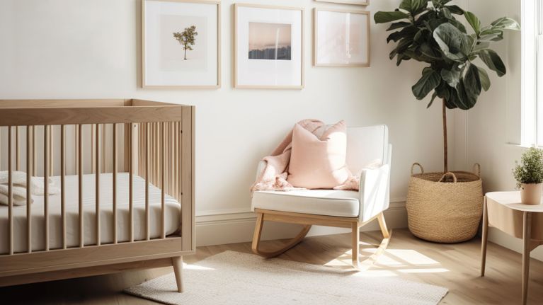 Bright, minimalist nursery with a wooden crib, rocking chair, framed wall art, and soft neutral decor lit by natural sunlight.