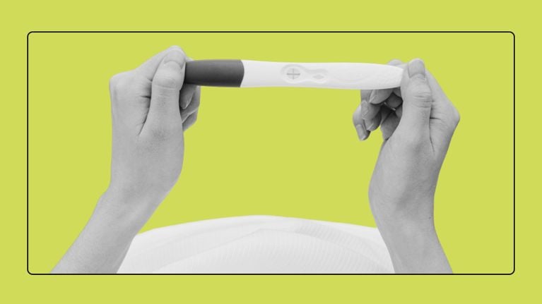 Hands holding a pregnancy test showing a positive result, framed against a bright green background.