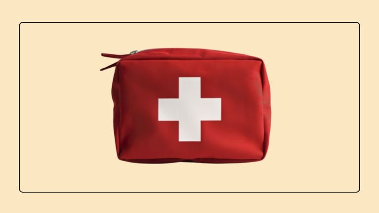 A red travel first aid kit with a white cross on a neutral background for family emergency preparedness.