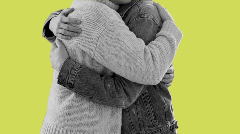 A black and white close-up of a parent and a teenager sharing a tight, emotional hug against a vibrant lime green background. One person wears a chunky knit sweater while the other wears a denim jacket.