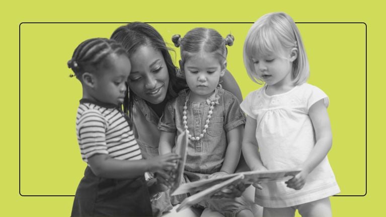 A teacher or caregiver reads a picture book to three diverse toddlers in a classroom setting.