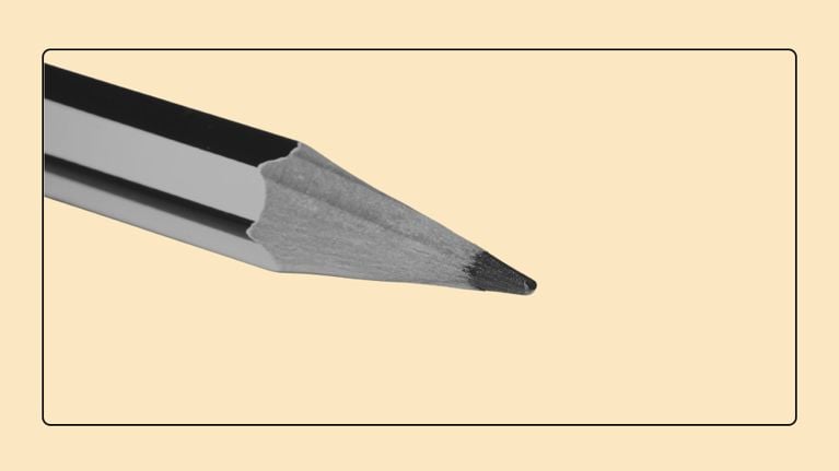 Close-up monochrome view of a sharpened pencil tip and exposed wood grain against a peach background within a frame.