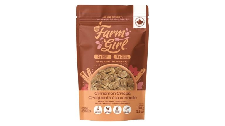 A brown stand-up pouch showing a bowl of square cinnamon cereal pieces. Icons at the bottom indicate the product is gluten-free, vegan, keto-friendly (no seed oils), and soy-free.