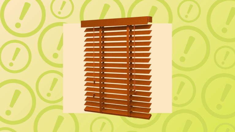 Wooden horizontal window blinds with pull cords over a background of green warning icons.