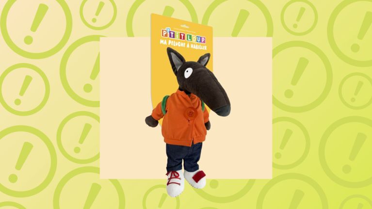 P’tit Loup "Ma Peluche à Habiller" wolf plush toy in orange jacket and jeans, centered against a yellow warning background.