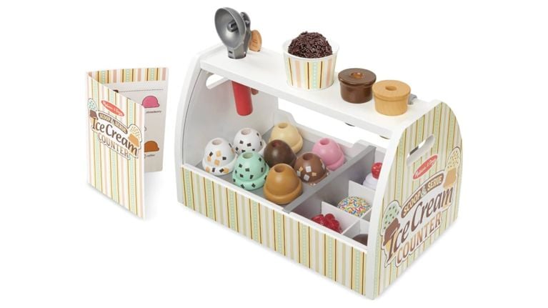 Melissa & Doug wooden Scoop & Serve Ice Cream Counter with various scoops, toppings, and a menu.