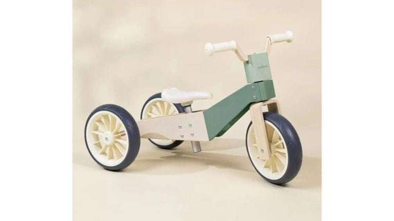 Coco Village Seafoam 3-in-1 Wooden Balance Bike. A minimalist wooden and sage green toddler tricycle with three wheels and cream-colored handles.