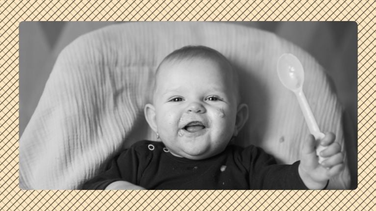 A baby of roughly 7 months of age lying on its back and smiling, seen from the shoulders up in black and white in front of a bright beige graphic background