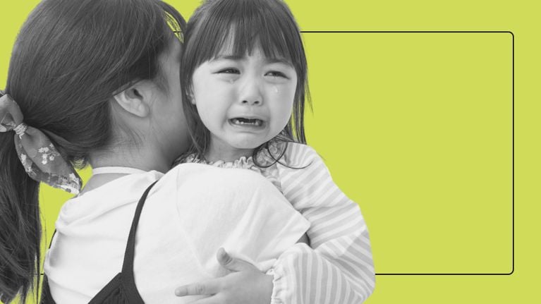 A young child crying and being comforted by their mother, capturing a moment of emotional toddler distress.