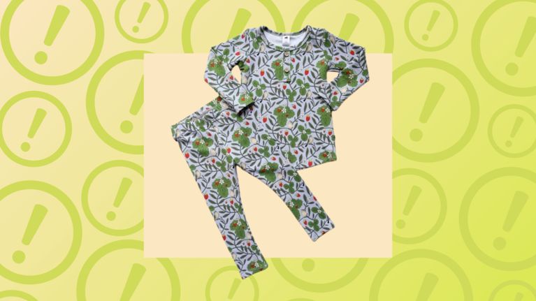 A set of strawberry-patterned children's pajamas over a yellow background filled with large exclamation point icons.