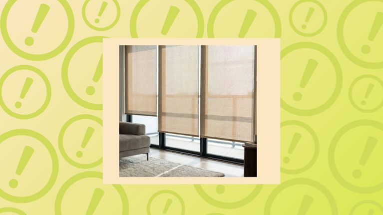 Three neutral-toned roller shades installed over a large glass balcony door in a modern, sunlit living room.
