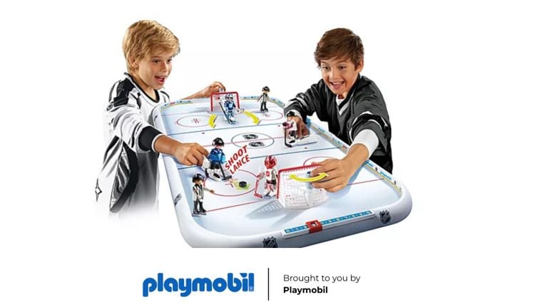 Two boys playing with a Playmobil NHL Hockey Arena, featuring movable players and a "shoot" function.