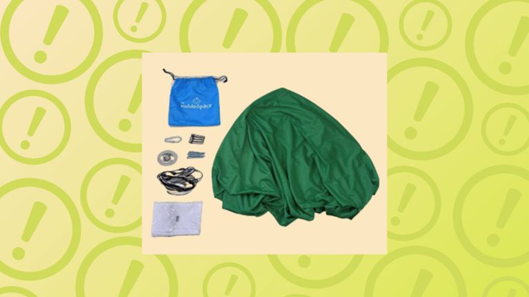 A dark green fabric sensory swing is displayed alongside its hanging hardware, which includes a blue drawstring bag labeled "The KiddoSpace," straps, screws, and clips. The items are centered inside a pale cream square box, overlaid on a lime green background with a repeating pattern of faded exclamation marks inside circles.