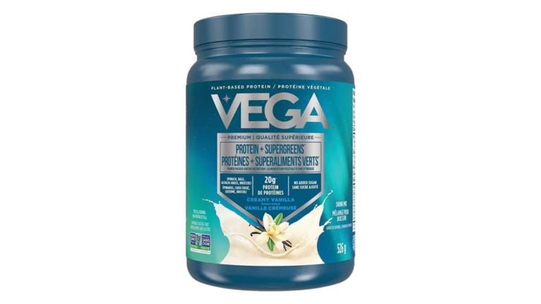 Vega Protein and Supergreens powder container in Creamy Vanilla flavor with a blue and teal label.