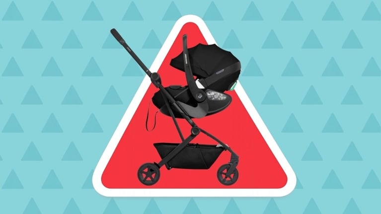 Black infant car seat attached to a Joolz stroller frame in front of a red warning triangle on a blue background, illustrating a product recall for a Joolz car seat adapter