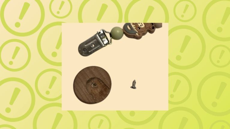 Graphic showing a disassembled pacifier clip with loose parts, including a metal clip, wooden piece and small screw, on a beige square over a green warning-themed background with exclamation marks.