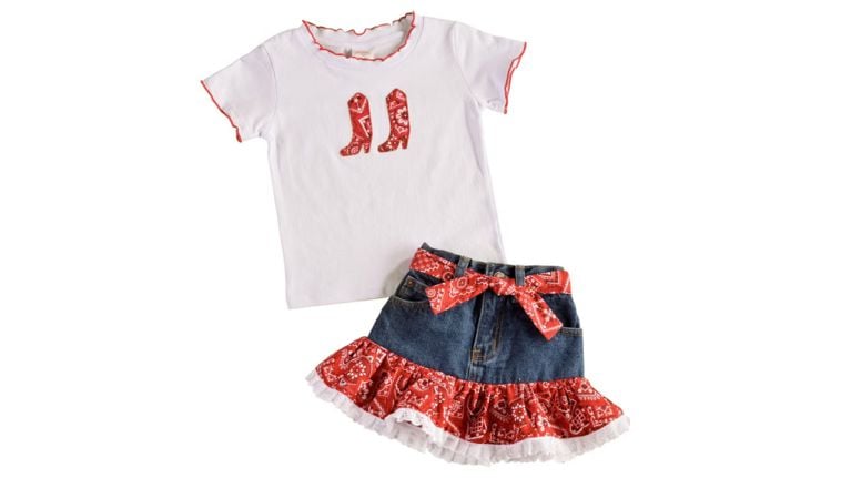 White kids’ short-sleeve T-shirt with red trim and a red cowboy boot graphic, paired with a denim skirt featuring a red bandana-print ruffle hem and matching sash belt, styled on a white background.