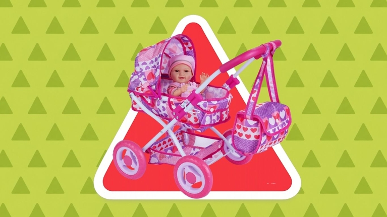 Pink and purple toy doll stroller with a baby doll and matching bag in front of a red warning symbol on a green background.