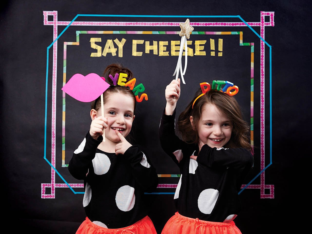 twins standing in front of photo booth