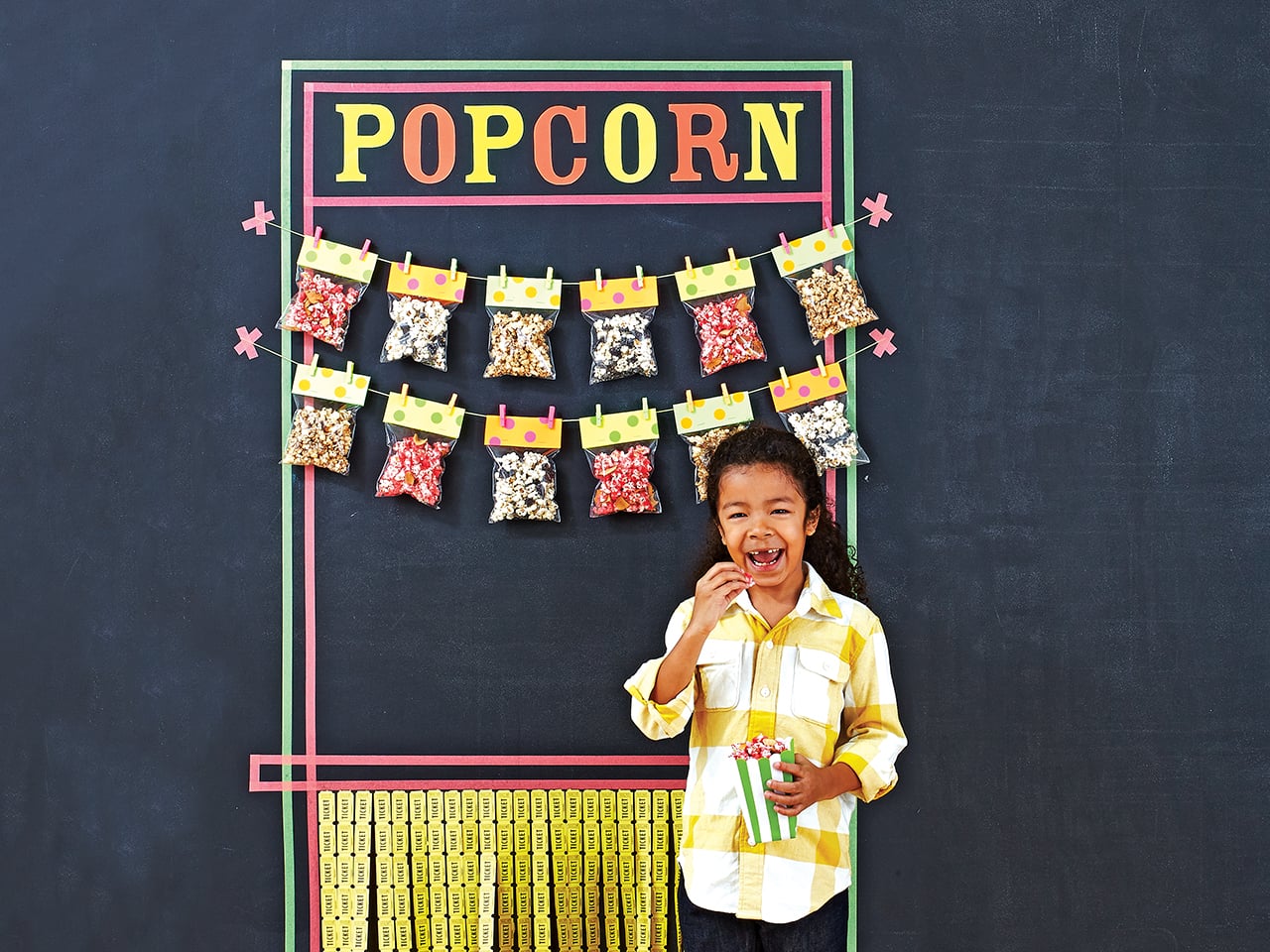 Child standing in front of a wall of bags of popcorn