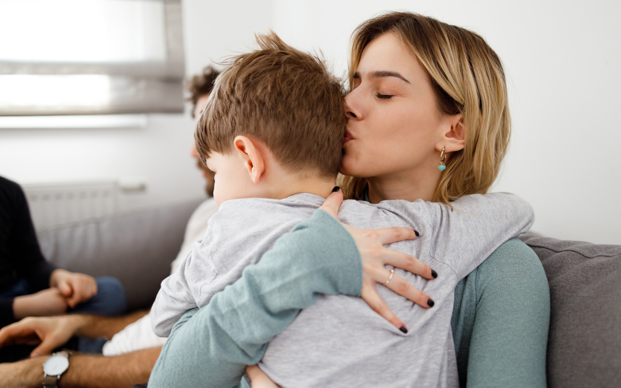 mom hugging son sitting on the couch
