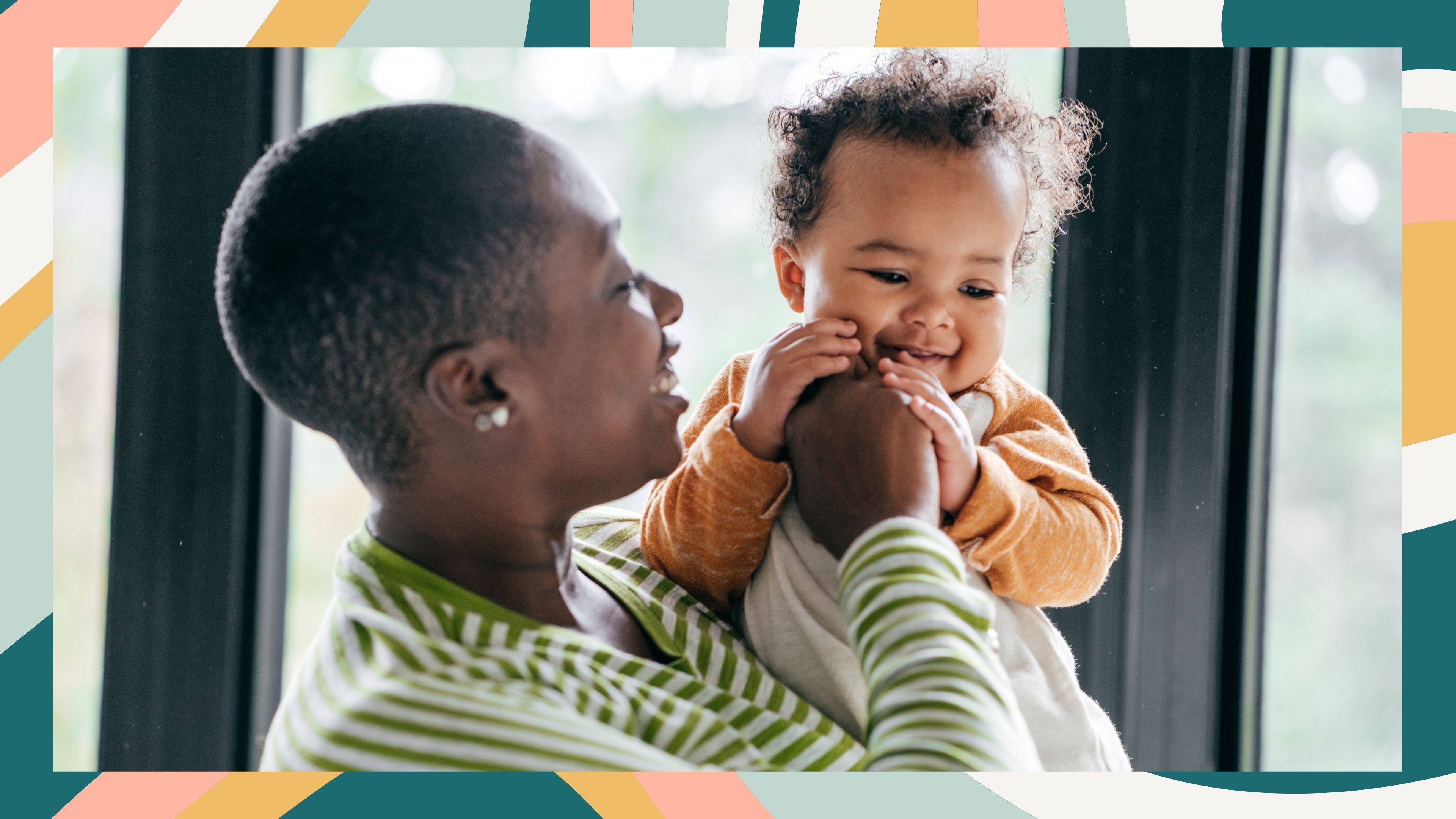A parent in a striped green top holds a smiling baby in a window-lit room—framed by cheerful multicolored stripes that echo the warmth of the moment.