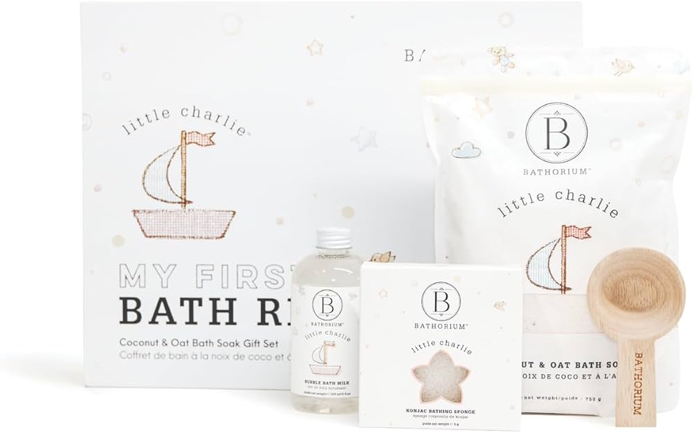 A baby bath gift set including bath soak, wash, sponge, and wooden brush packaged in soft neutral tones.
