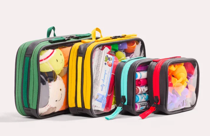 Four clear zippered organizer bags in different sizes and colors, filled with toys, markers, and small items.
