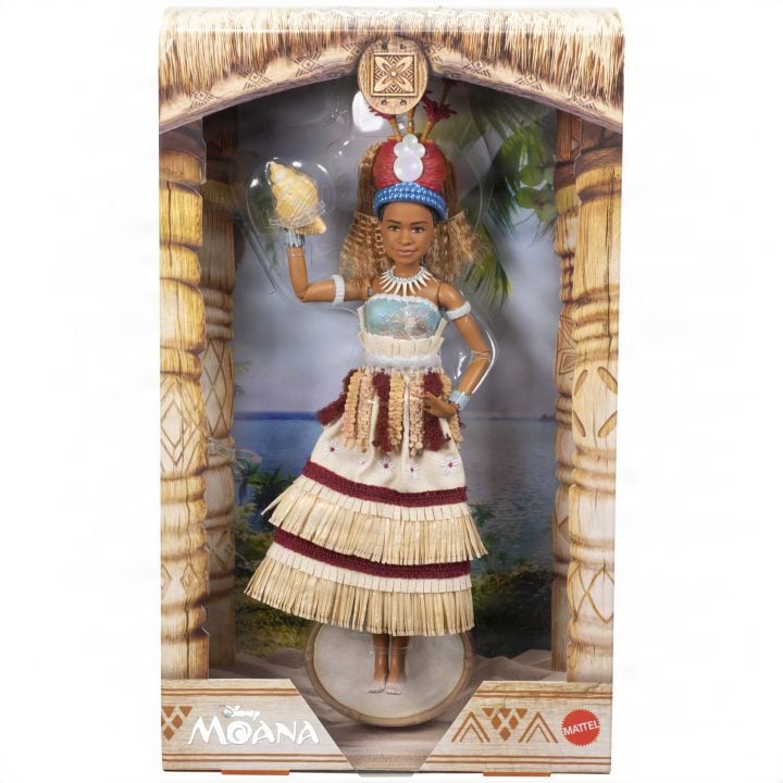 Moana fashion doll in a ceremonial feathered headdress and woven outfit, displayed in a tropical-themed box.